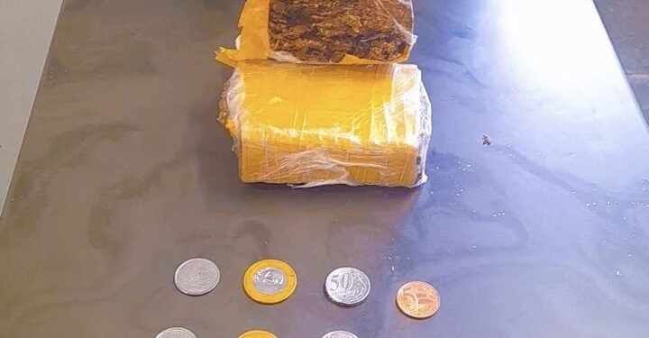 Foram apreendidos um tijolo de maconha dividido em duas partes, um aparelho celular e três reais em moedas.(Divulgação)
