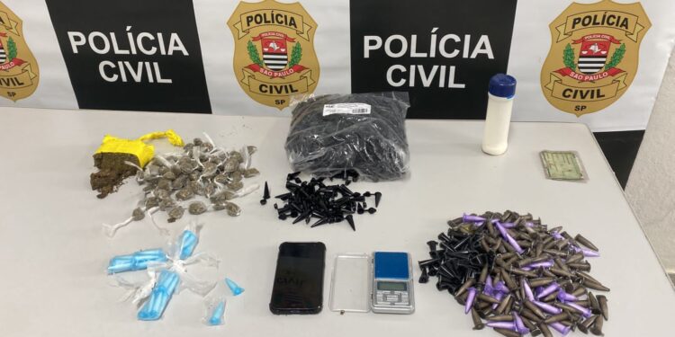 Com eles foram apreendidos, em sacos escondidos no meio dos lixos, nos fundos da residência, uma sacola 278 de cocaína, 83 porções de maconha, uma porção, à granel, da mesma droga, 1000 embalagens vazias, balança de precisão e aparelho celular. (Divulgação/ Polícia Civil)