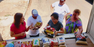 Pessoas com pacotes de alimento. (Divulgação)