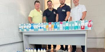 Homens com várias caixas de leite. (Divulgação).