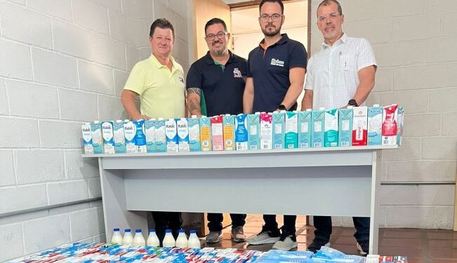 Homens com várias caixas de leite. (Divulgação).