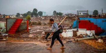 Mulher andando por local alagado. (Divulgação)