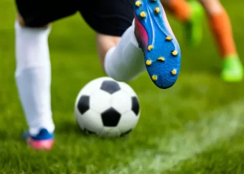 Atletas disputam bola em partida de futebol (Freepik)