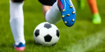 Atletas disputam bola em partida de futebol (Freepik)